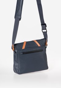 Marine Messenger Bag mit braunen Lederakzenten, verstellbarem Tragegurt, Reißverschluss-Vortasche und glattem, strapazierfähigem Material. Abgerundete Form.