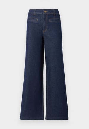 Pantalons en denim à jambes larges de couleur bleu foncé, avec une taille haute, une fermeture par bouton supérieur et des coutures orange contrastantes. Deux poches arrière visibles.