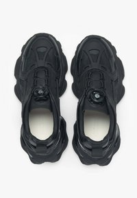 Czarne buty sportowe z siateczkową cholewką, zaokrąglonym kształtem, grubą podeszwą oraz okrągłym pokrętłem do regulacji sznurowania.