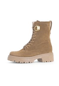 Brune semsket ankelstøvlett med snøring foran, sidestrapsdetalj, kraftig beige såle og teksturerte detaljer. Myk overflate med slitesterk design.