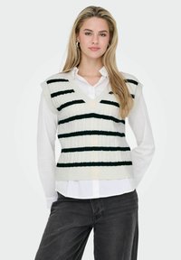 White knitted vest with dark green stripes, featuring a v-neckline and cable knit texture, layered over a collared white shirt.