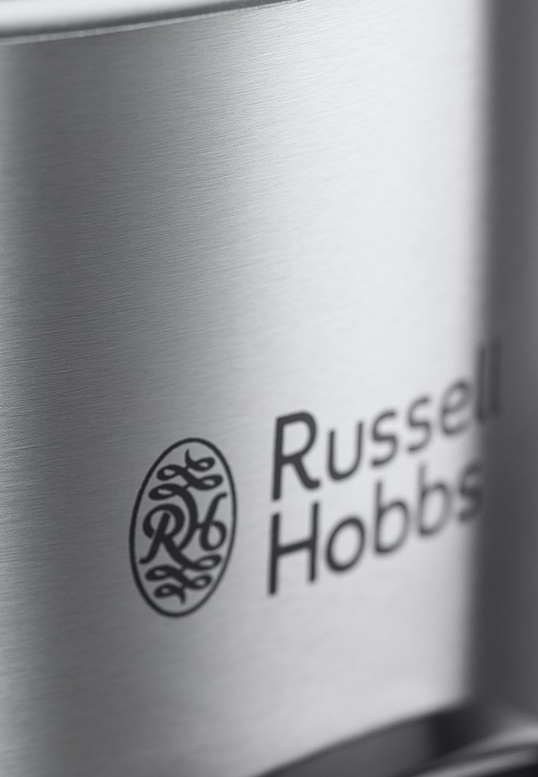 Powierzchnia czajnika ze stali nierdzewnej o szczotkowanej teksturze, z wyraźnym logo Russell Hobbs i okrągłym akcentem. Elegancki i nowoczesny design.