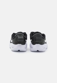 Baskets de sport noires avec une tige en mesh, un col rembourré et une semelle en caoutchouc blanche, portant l'inscription 'STAR RUNNER 04' en relief sur le talon.