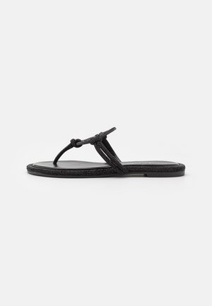 Black flat sandals with a knotted fabric strap and textured sole, featuring a minimalist design and flexible construction.
