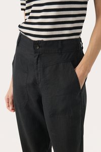 Black linen trousers with front pockets, featuring a button closure and a relaxed fit. Textured fabric with subtle stitching details.