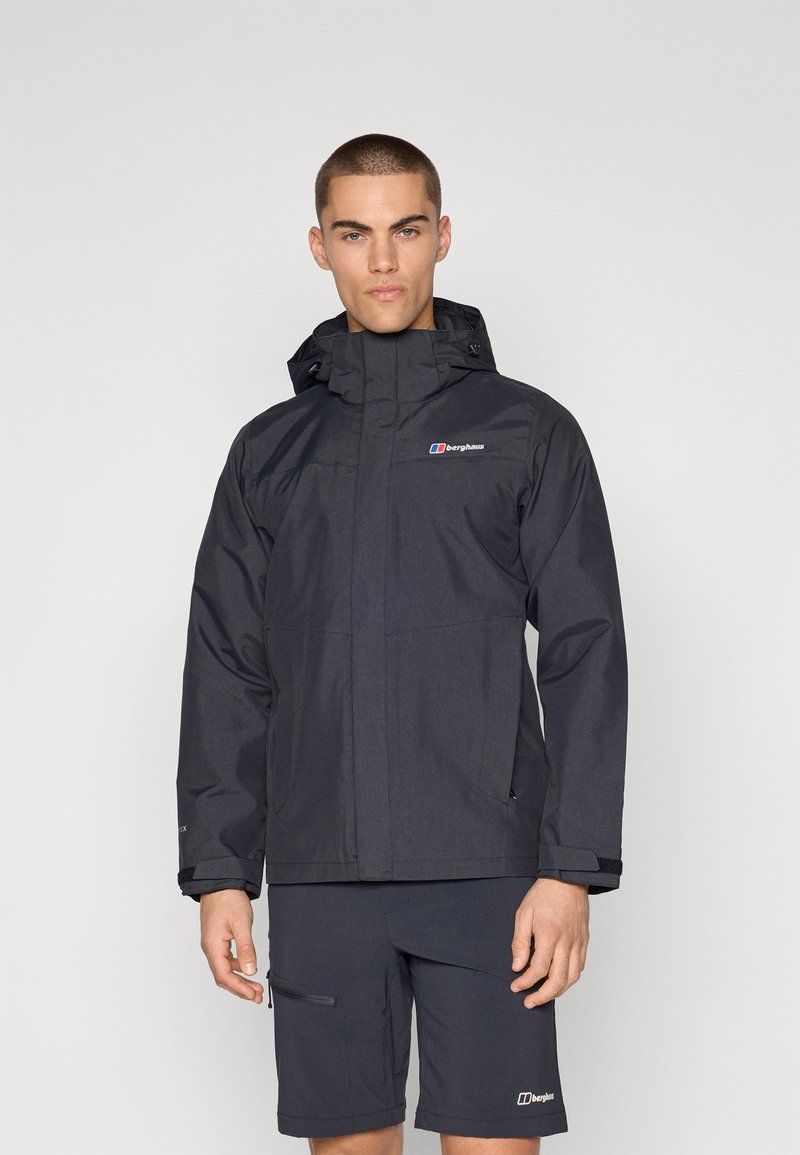 Chaqueta impermeable negra con cremallera y capucha ajustable, que presenta un logo en el pecho, mangas largas y dos bolsillos laterales.