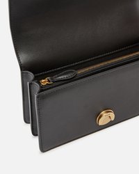 Borsa a mano in pelle nera con cerniera e accessori in oro, caratterizzata da un interno spazioso e una disposizione organizzata dei scomparti.