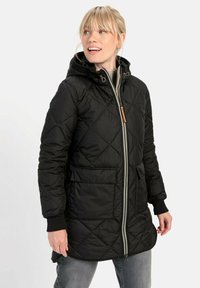 Schwarzer gesteppter Mantel mit Kapuze, ausgestattet mit einem Frontreißverschluss, zwei großen Taschen und gerippten Bündchen. Textilstoff mit Rautenmuster.