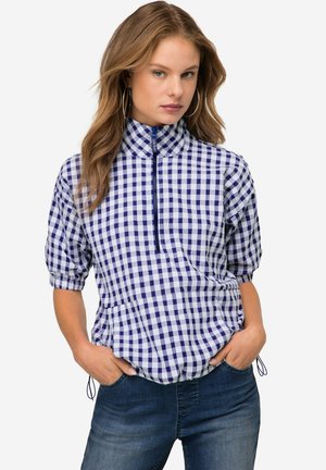 Camicia a scacchi blu e bianca con colletto alto, chiusura a metà zip davanti e maniche a sbuffo. Il materiale sembra leggero con un dettaglio di vita sottomessa.