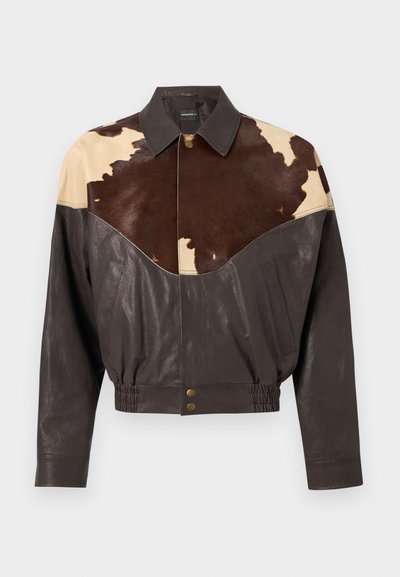 Hnedá kožená bunda s tmavými a svetlohnedými panelmi z hovädzej kože na hornej časti hrudníka a ramenách, zapínanie na gombíky, elastický pás a bočné vrecká.