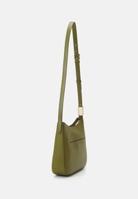 Bolso de hombro de cuero verde oliva con correa ajustable, textura suave, forma delgada y un pequeño bolsillo exterior. Acento en tono dorado.
