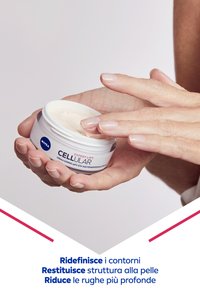 Crema anti-invecchiamento NIVEA CELLULAR in un barattolo bianco con un coperchio argentato. Formula cremosa e chiara su una mano con unghie chiare.