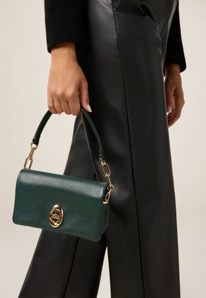 Borsa a mano verde in pelle con finitura testurizzata e tracolla rimovibile, caratterizzata da una chiusura circolare dorata e da una forma rettangolare.