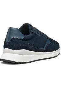 Sneaker da uomo blu navy che presenta un mix di suede e pelle, con suola in gomma bianca, punta arrotondata e dettagli testurizzati.