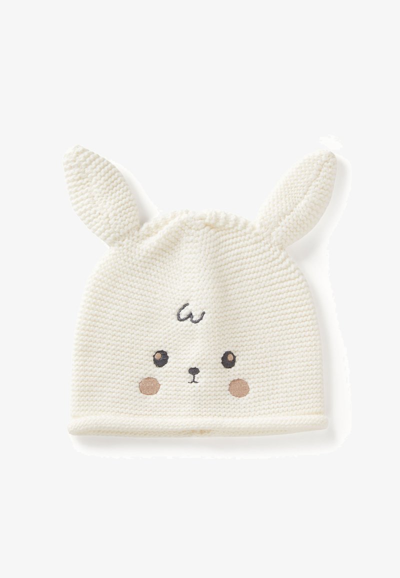 Gorro blanco de punto con orejas de conejo, con detalles de cara bordados, incluyendo ojos negros y mejillas marrones. Textura suave.