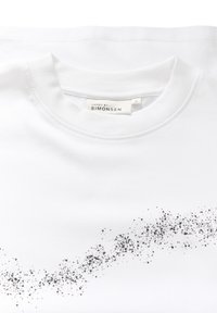 Witte katoenen T-shirt met een ronde halslijn en een verspreid zwart stippenpatroon op de voorkant. Het etiket vermeldt "KAREN BY SIMONSEN."