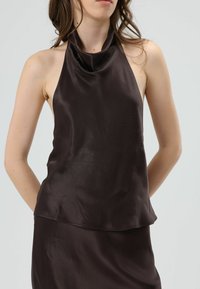 Donkerbruine haltertop van een glad, satijnen stofje, met een losse pasvorm en een gedrapeerde halslijn. Geen zichtbare patronen of hardwaredetails.