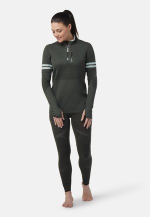 Top atletico verde scuro con collo a zip e dettagli a strisce, abbinato a leggings coordinati con motivi testurizzati e vestibilità aerodinamica.