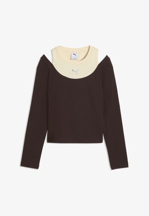 Brun top med lange ærmer og bare skuldre lagdelt over en beige tanktop med en lille Puma-logo midt på halsudskæringen.
