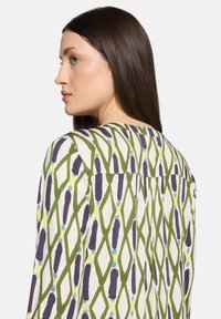 Koszula z długim rękawem z lekkiej bawełny z wielokolorowym, geometrycznym wzorem w zieleni, fiolecie i niebieskim, z plisą z tyłu.