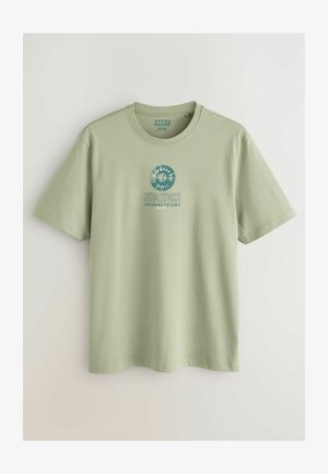 Világoszöld pamut póló, rövid ujjú, kerek nyakkivágással és középen elhelyezett kék és fehér színű grafikai nyomattal.