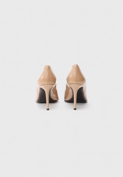 Visoke petke iz lakiranega usnja v naravni barvi. Končni prsti z elegantno, visoko tančico peto. Gladek tekstura in minimalističen slog.