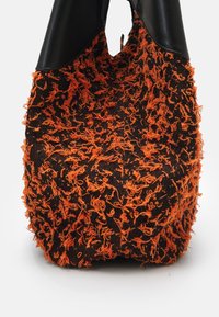Borsa nera con una finitura in filo testurizzato arancione. Presenta una parte superiore in pelle nera liscia, una forma arricciata e un design con apertura sulla parte superiore.