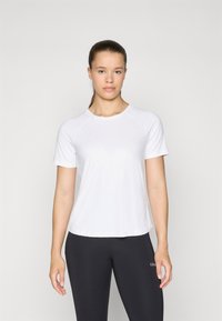 T-shirt bianco a maniche corte in tessuto leggero con colletto rotondo e maniche raglan, abbinato a leggings neri con dettaglio del logo.