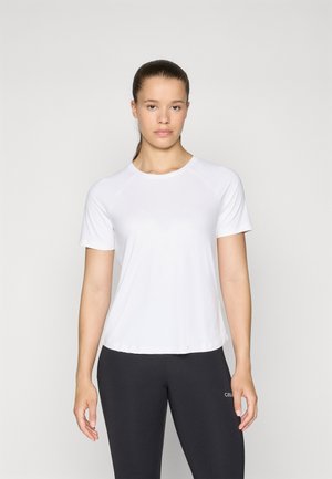 Vit t-shirt med korta ärmar i lätt tyg, rund halsringning och raglanärmar, stylar med svarta leggings med logotypdetalj.