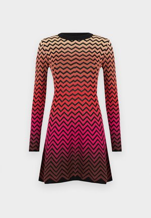 Robe tricotée avec un motif en zigzag dans des nuances dégradées de beige, rouge et noir. Manches longues et col rond.