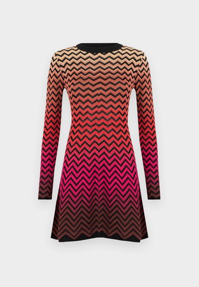 Vestuário tricotado com um padrão em zig-zag em tons degradê de bege, vermelho e preto. Mangas longas e design de gola redonda.