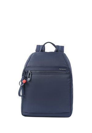Navy blue Hedgren backpack with front zip pocket, top handle, padded shoulder straps, and a small red keychain attached to the zipper.