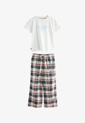 Biały T-shirt z krótkim rękawem z napisem "Superdry & Co", zestawiony z luźnymi, kremowymi spodniami w kratę z czerwonymi i niebieskimi paskami oraz wiązanym paskiem w pasie.
