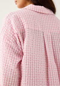 Koszula z długim rękawem w różowo-białą kratę, z teksturowanej tkaniny, z kołnierzykiem i detalami w postaci plisek z tyłu.