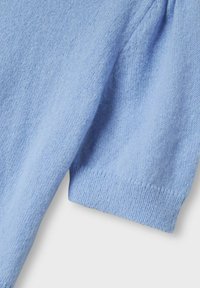 Lyseblå strikket sweater med korte ærmer, der har en blød tekstur og ribbet kantdetalje. Stoffet fremstår let og åndbart.