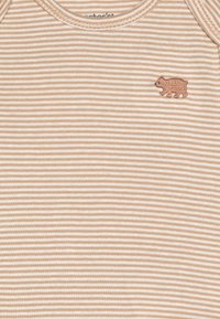 Bodysuit rayé beige et blanc en coton doux, avec une petite broderie d'ours brun sur la poitrine et un col arrondi.