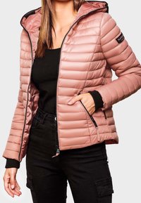 Różowa kurtka puchowa z poziomym pikowaniem, czarnymi akcentami, kieszeniami na zamek i odpinanym kapturem. Posiada logo na rękawie.