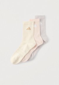 Τρία ζευγάρια ριμπ κάλτσες: κρεμ, ανοιχτό ροζ και ανοιχτό γκρι. Καθένα έχει ένα μικρό λογότυπο σε αντίθετο χρώμα. Μαλακή υφή υφάσματος.