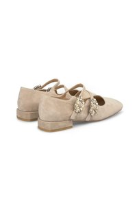 Beżowe zamszowe płaskie buty z ostrym noskiem, ozdobnymi kryształowymi akcentami i dwoma paskami. Niski, stożkowy obcas i gładka faktura.