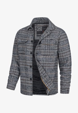 Veste chemise à carreaux dans des tons gris, noir et orange. Comprend une fermeture à boutons sur le devant, des poches poitrine et un intérieur doublé pour plus de chaleur.