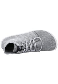 Gray athletic shoe with a breathable mesh upper, white sole, elastic laces, and minimalistic design. No visible logo on the upper.