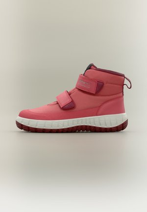 Zapatilla deportiva impermeable rosa de caña alta con doble tiras de velcro y suela blanca texturizada sobre fondo liso.