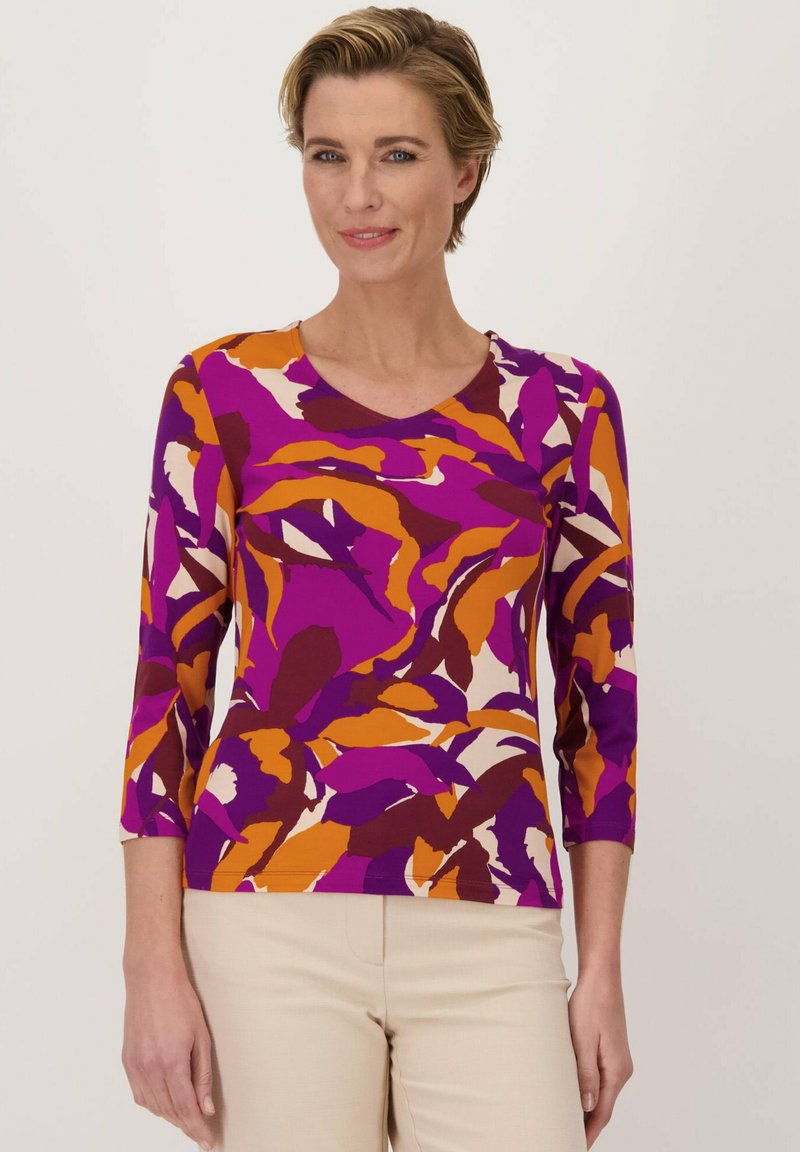 V-hals, aansluitend top met 3/4 mouwen. Kenmerkt zich door een levendige paarse, oranje en crèmekleurige abstracte bladenprint op een zachte stof.