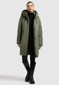 Olivgrüne Daunenjacke mit Kapuze, ausgestattet mit einem Reißverschluss und Knopfverschluss, zwei Fronttaschen und einem weichen Innenfutter. Länge bis zur Mitte des Oberschenkels.