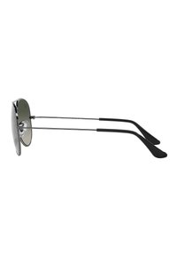 Occhiali da sole con una montatura in metallo argentato, punte nere e lenti rotonde scure; presentano aste sottili e un design minimalista.