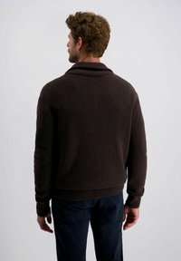 Bruine, gestructureerde trui met een geribbelde kraag en manchetten. De achterkant laat een ontspannen pasvorm en een effen patroon zien. Geschikt voor casual attire.