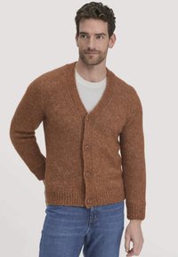 Brauner Strickcardigan mit V-Ausschnitt, Fünf-Knopf-Verschluss und gerippten Bündchen. Über einem weißen Hemd getragen, mit einer strukturierten, weichen Erscheinung.