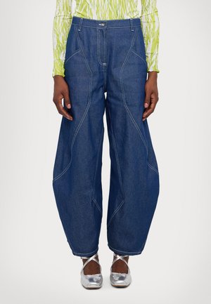 Mørkeblå denim bukser med brede ben og kontrasterende hvid syning, med høj talje og unikke skrå sømdetaljer.