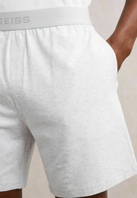Szare bawełniane szorty z elastycznym paskiem w talii, z delikatnym logo. Materiał ma miękką, teksturowaną fakturę oraz boczne kieszenie.