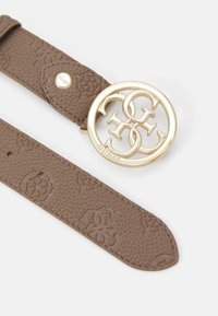 Rudas tekstūruotas odinis diržas, kuriame yra įspaustas raštas ir didelis auksinės spalvos apvalus sagtis su susipynusiomis inicialais ir prekės ženklu.